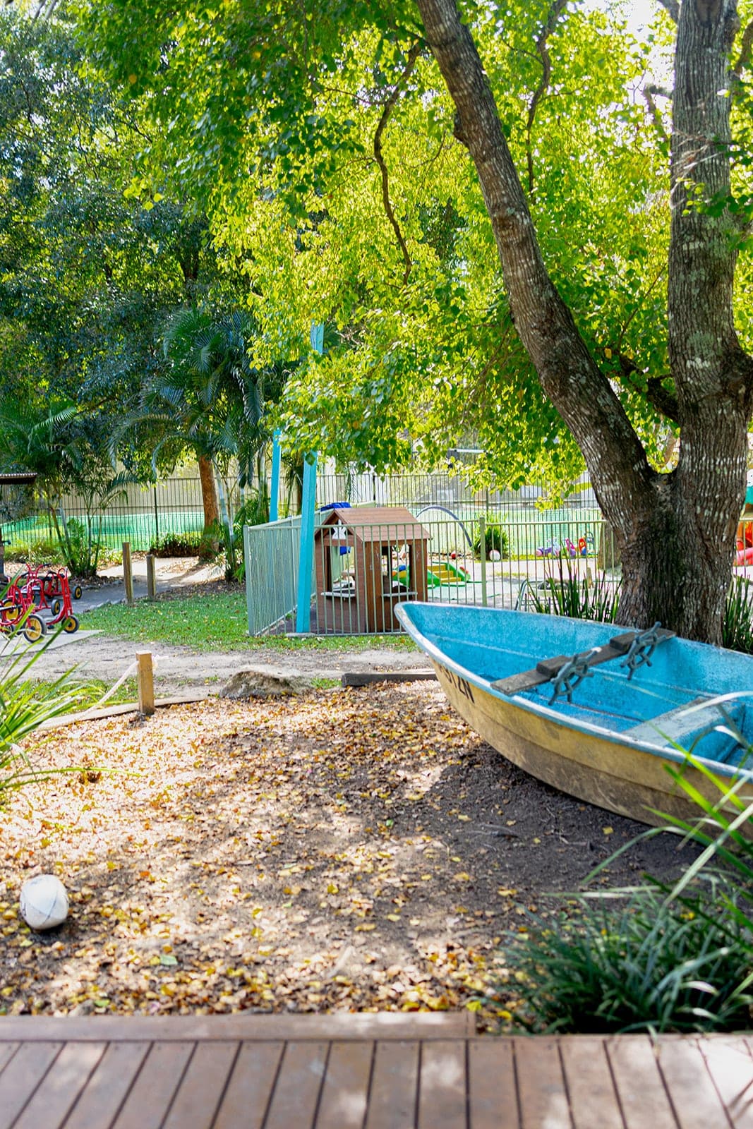 Old tinny boat used as a play space beneath a big tree