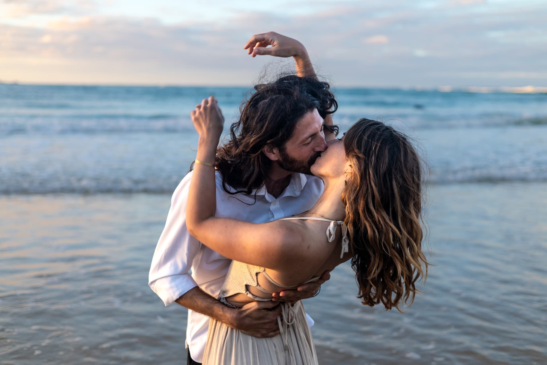 Couple kissing in the shallows at sunset