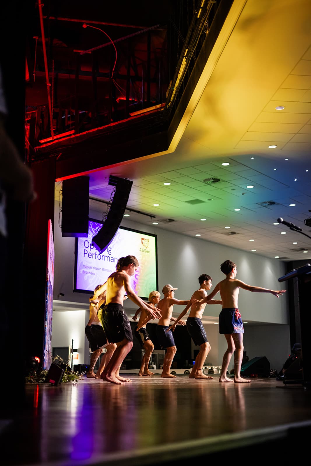Opening performance on stage beneath the conference screen