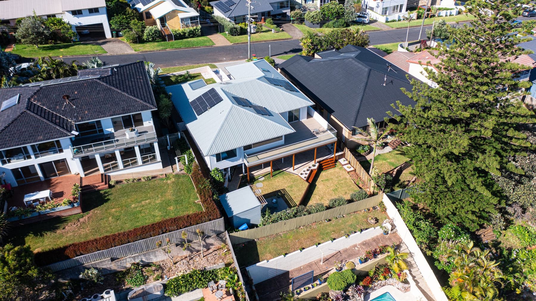 Aerial looking down on homes, terraced lawns and a pool