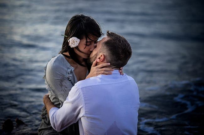 Moody blue portrait of a couple kissing in dark water