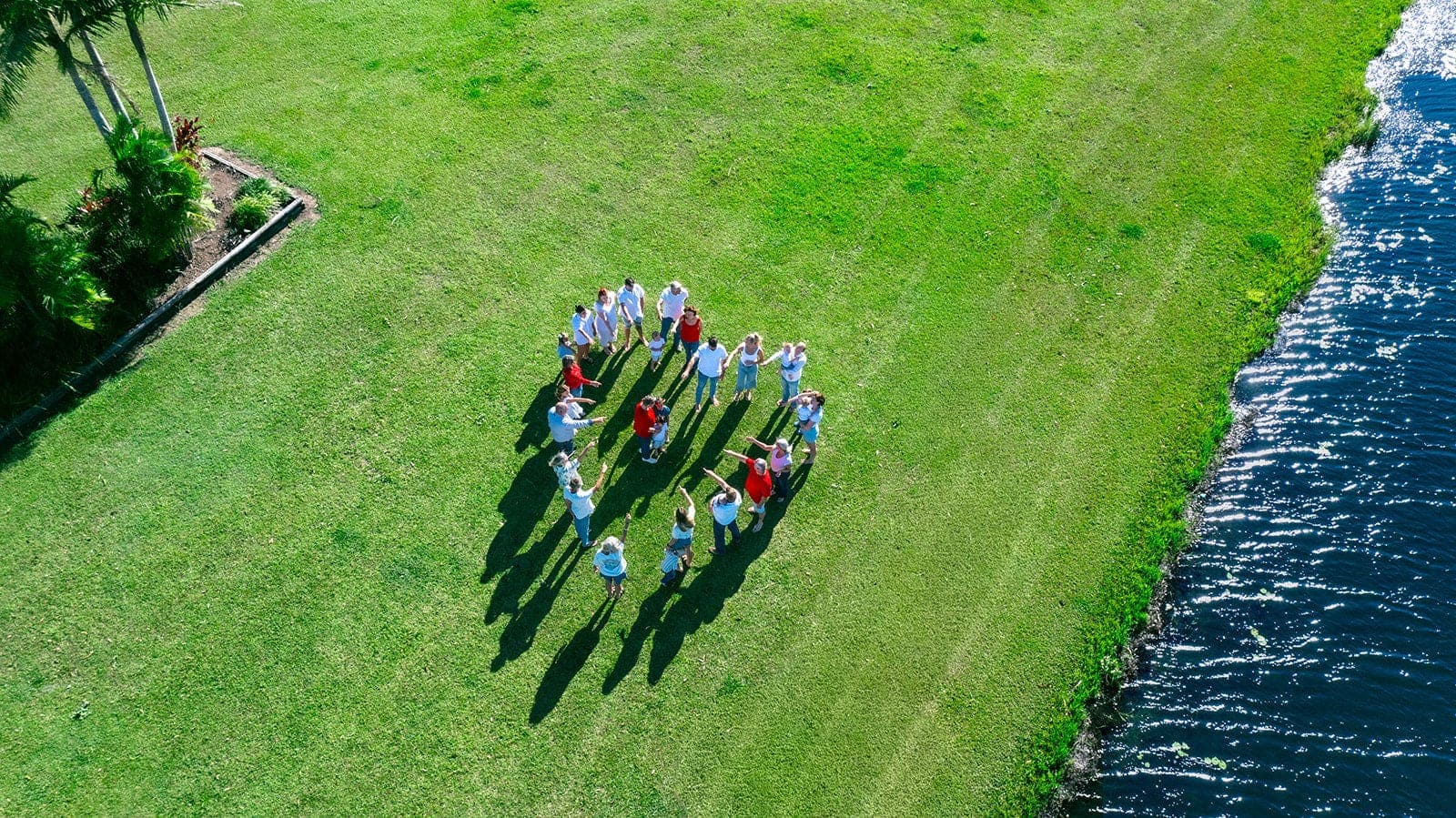 Aerial of a large group forming a heart on green grass
