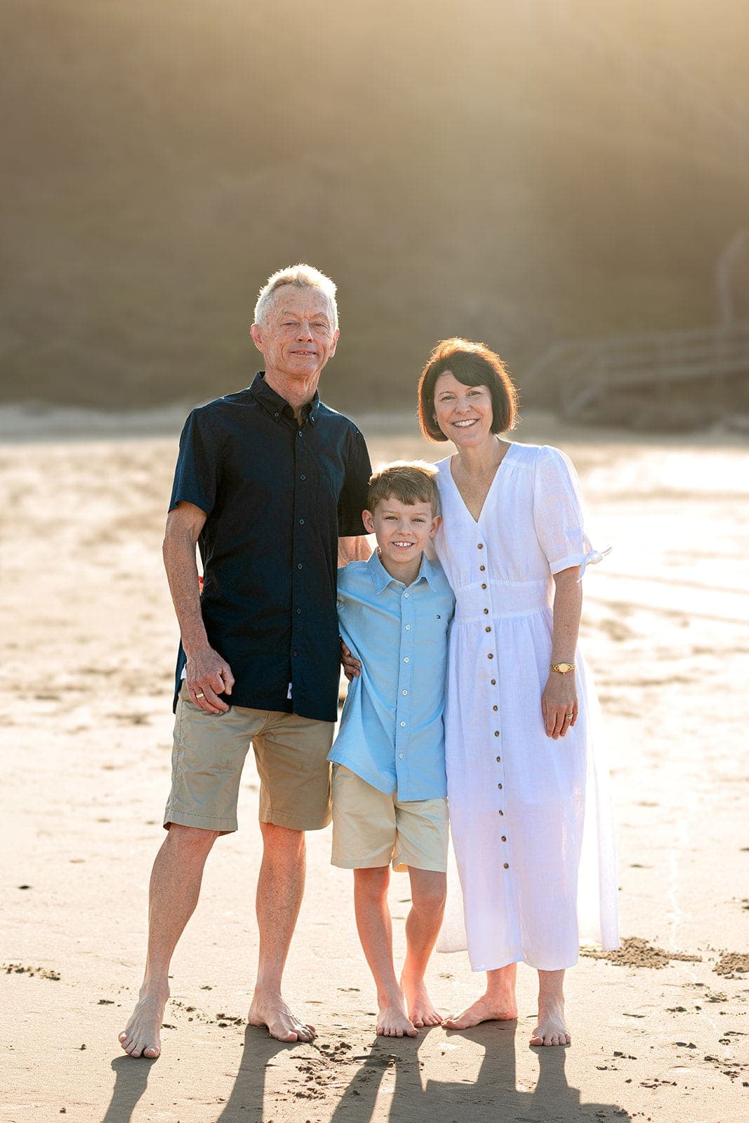 Grandparents and grandson standing together on the beach