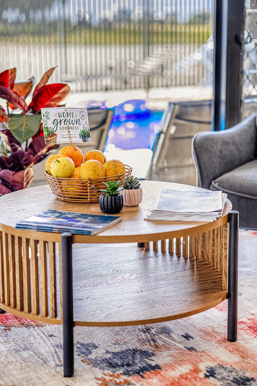 Lobby coffee table with a basket of home-grown citrus and magazines beside the pool