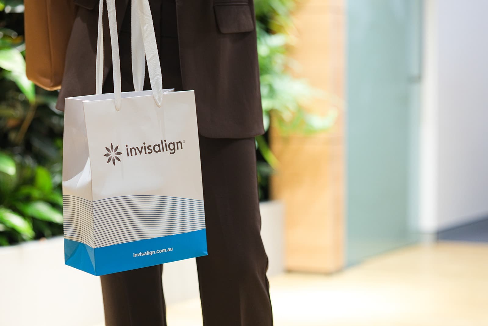 Patient carrying an Invisalign gift bag through the clinic