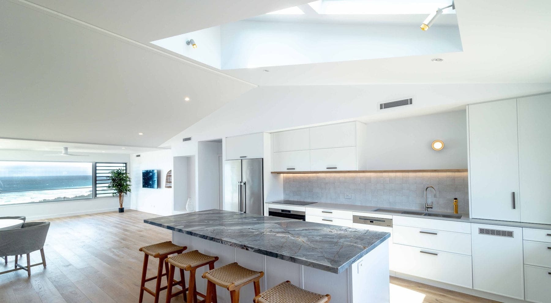Bright kitchen with a marble island and timber stools