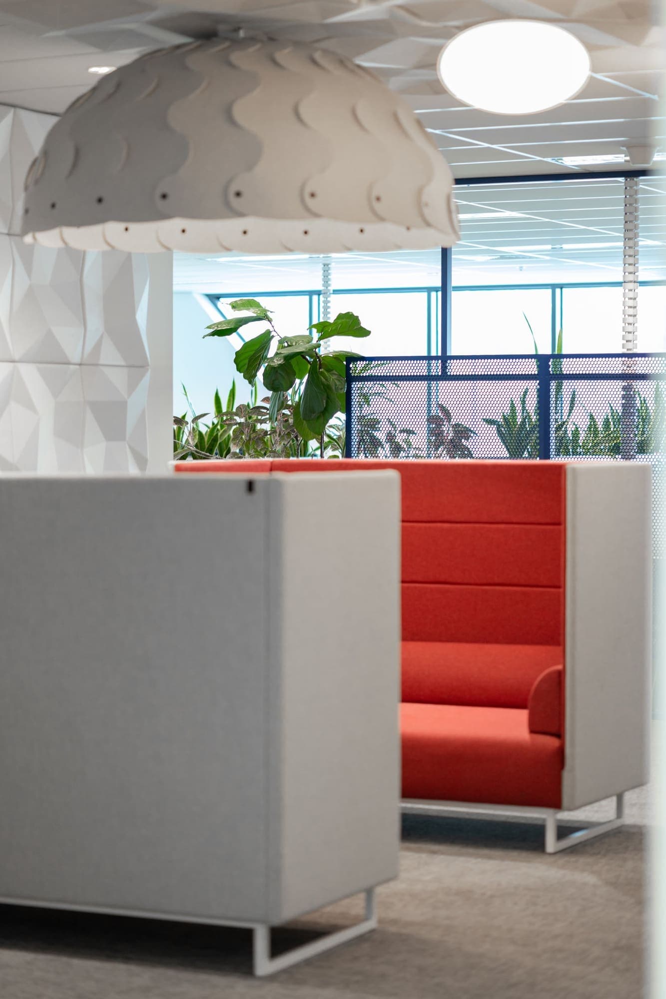 Office fit-out with red booth seating and planters