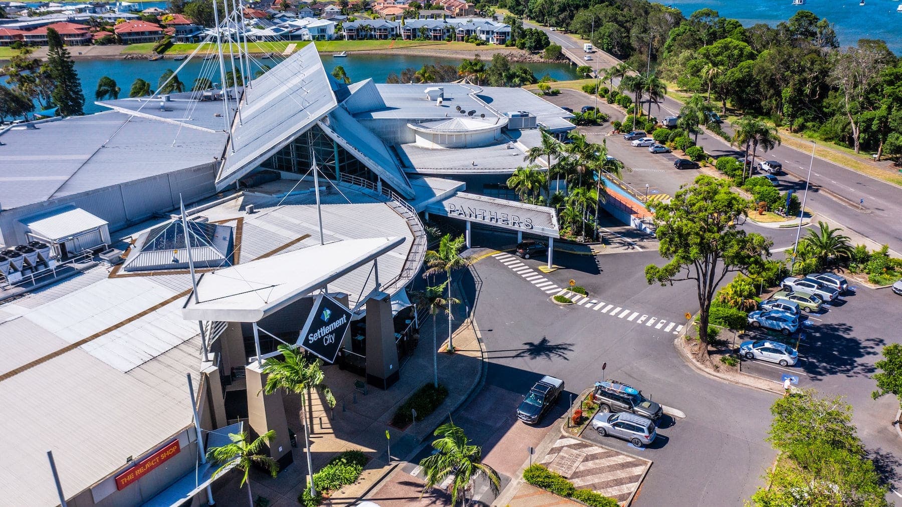 Aerial of a sail-roofed building and car park