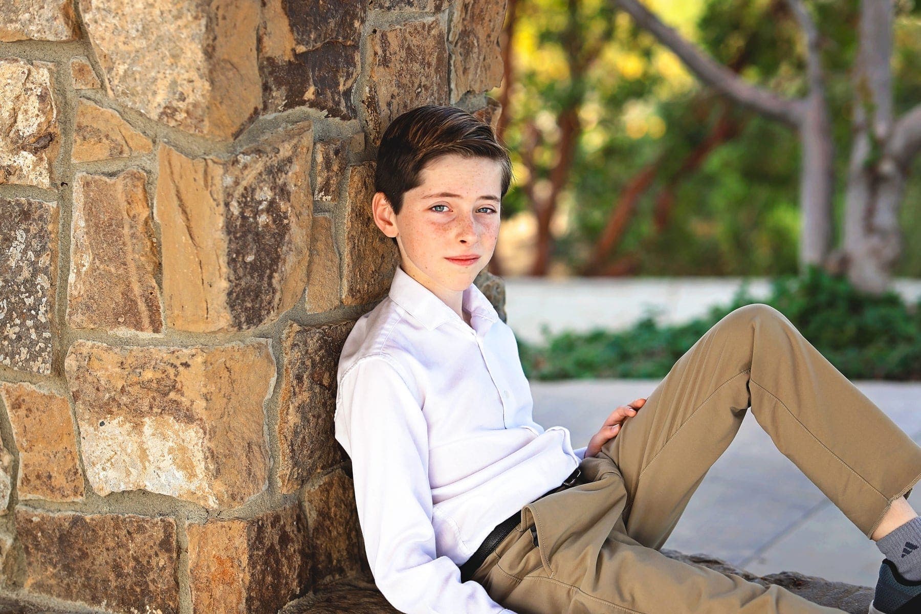 Portrait of a boy leaning against a sandstone wall