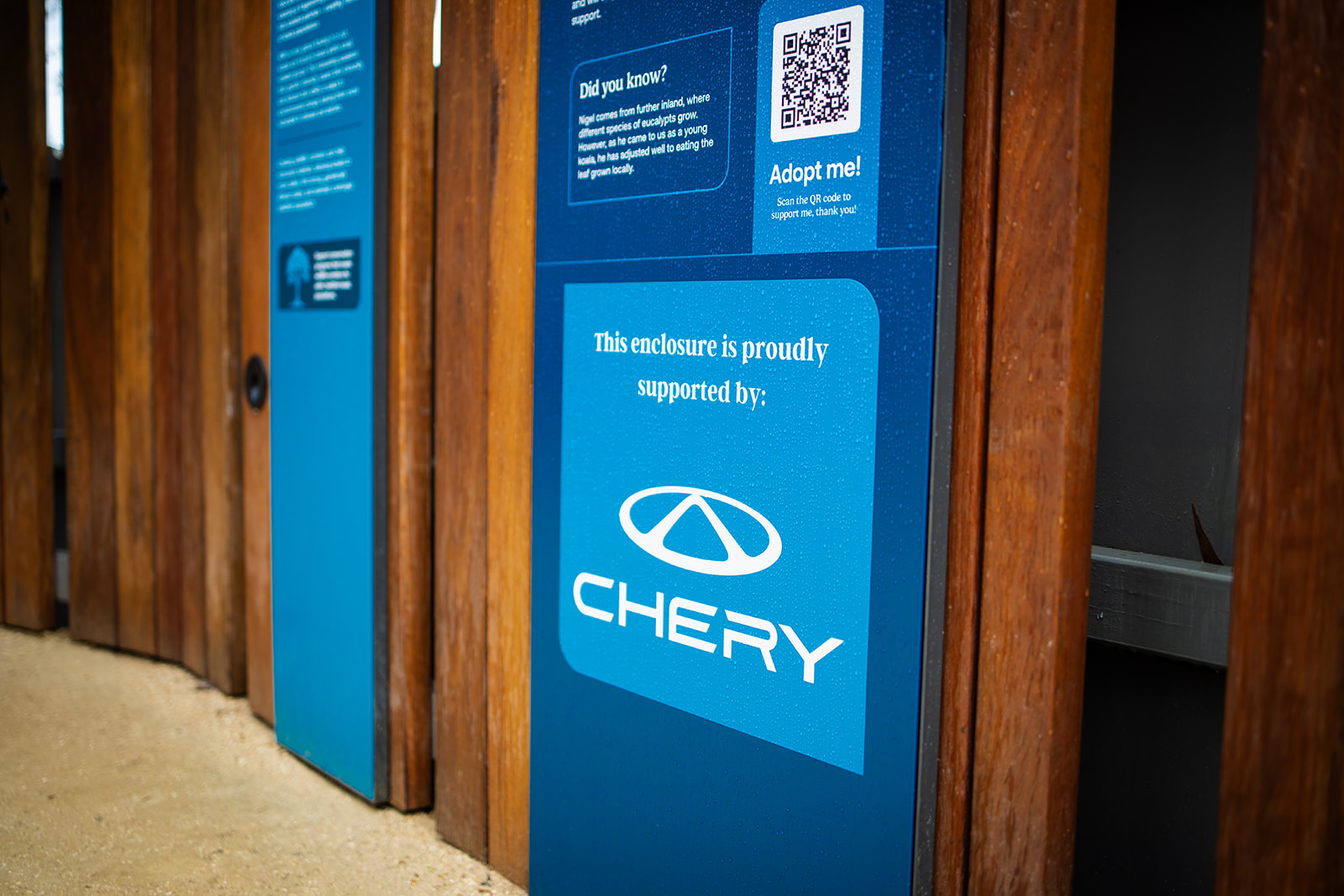Automotive sponsorship signage on a koala enclosure reading "This enclosure is proudly supported by" the sponsor