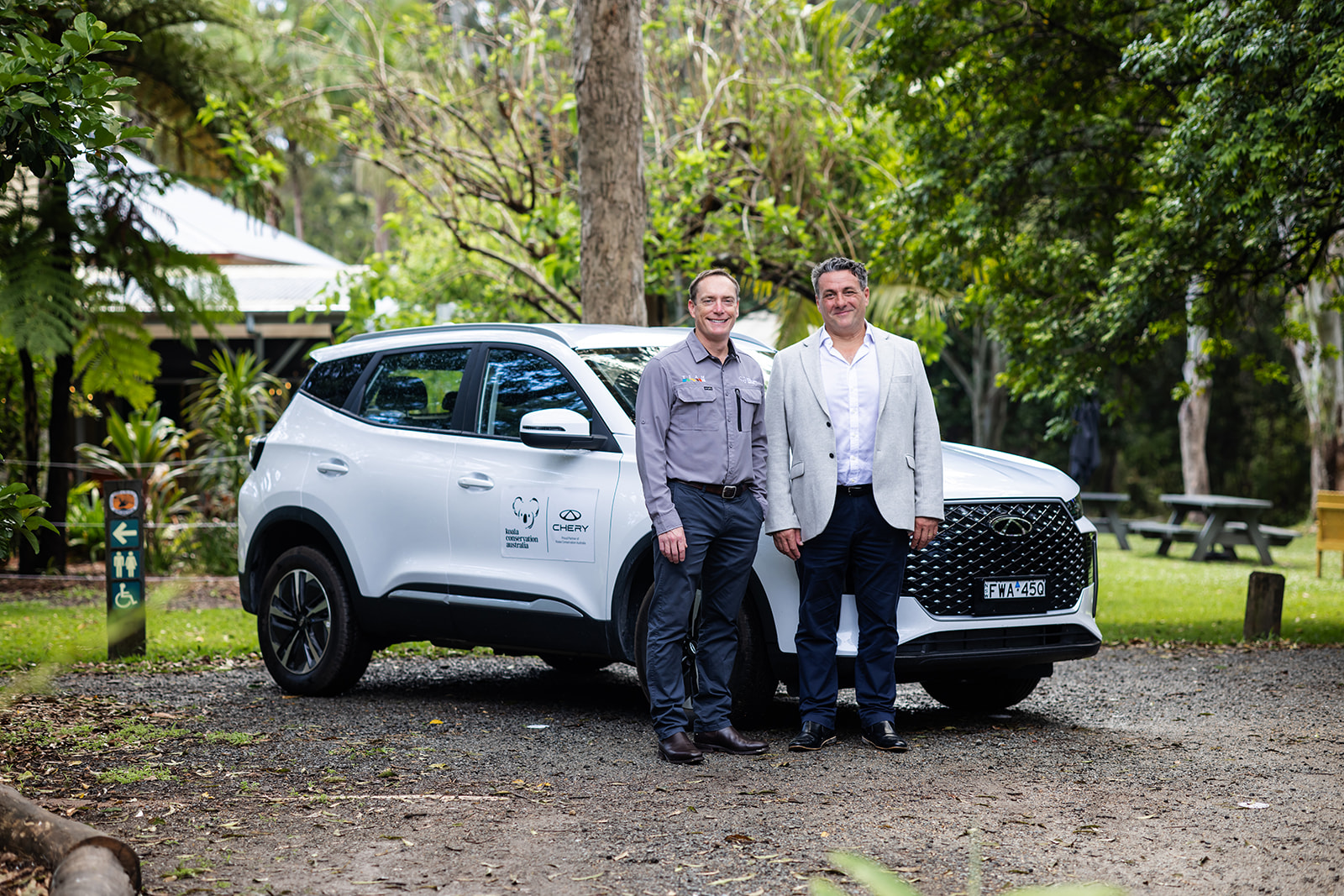 Koala Conservation Australia and automotive sponsor representatives standing beside a white co-branded SUV